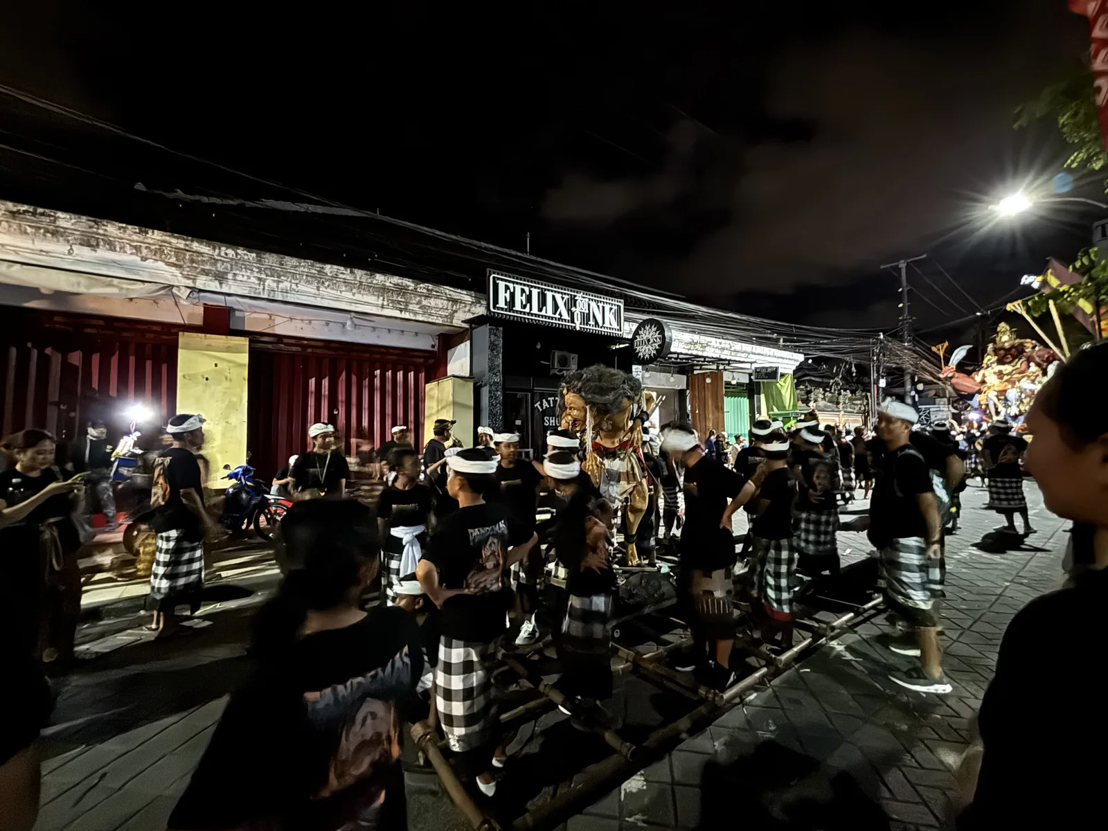 峇里島寧靜日前夜 Ogoh-ogoh 遊行的街頭隊伍，身穿黑白格紋紗籠