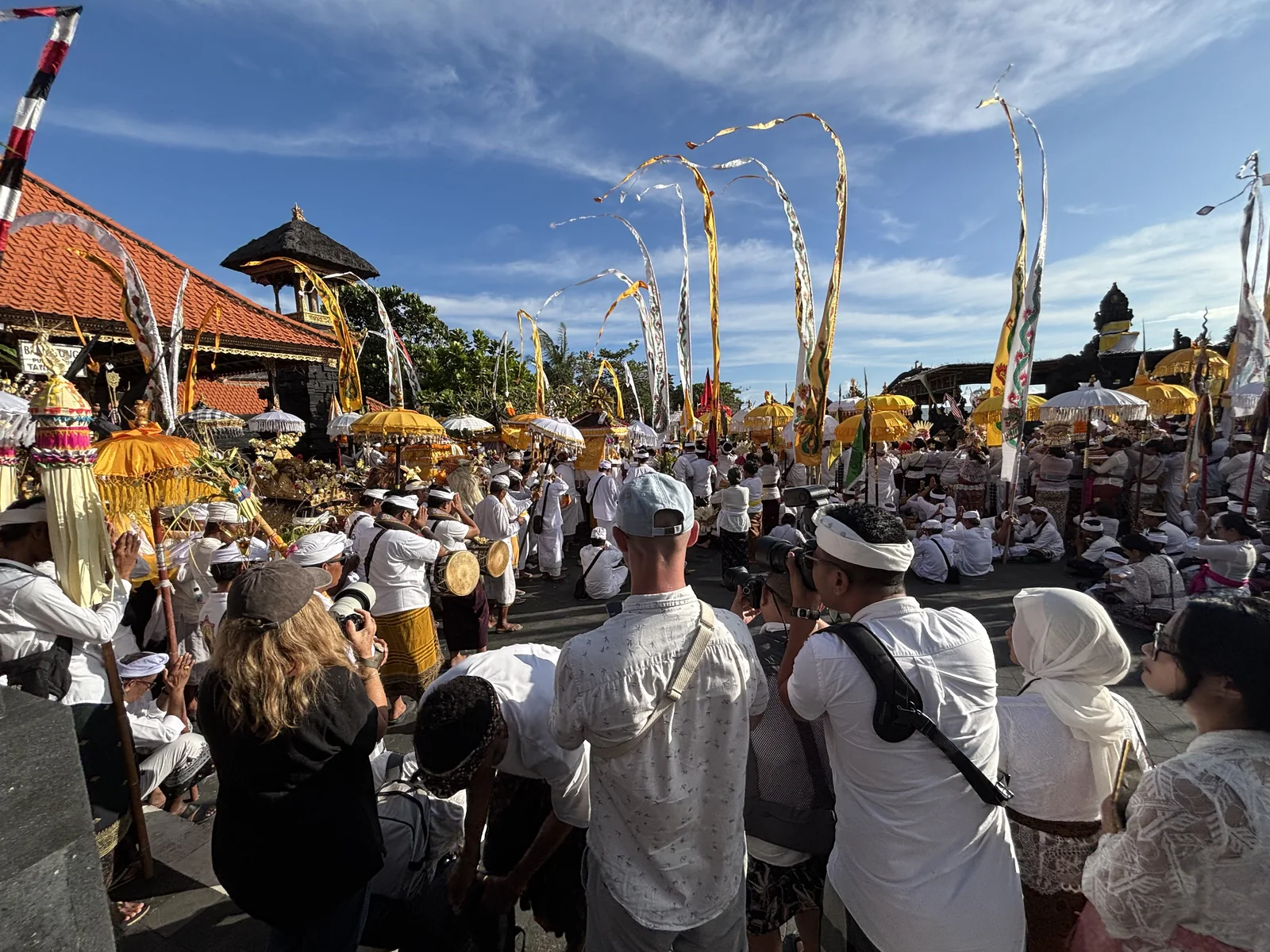 峇里島海神廟 Tanah Lot 的 Melasti 潔淨儀式，白衣信眾與傳統陽傘、長幡