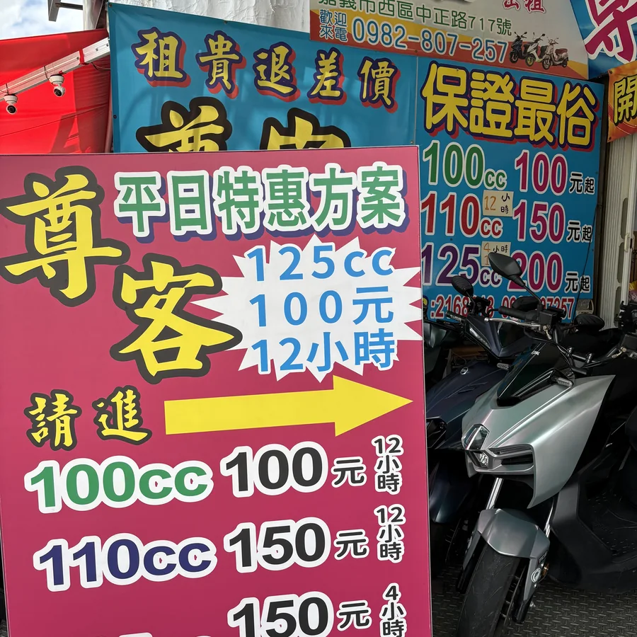 嘉義火車站前租機車行的實拍價目板，標示 100cc、110cc、125cc 各時段租金