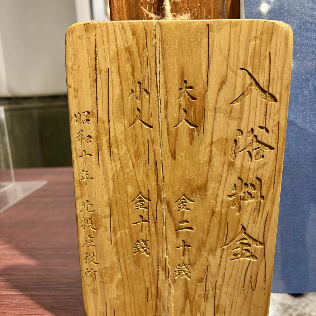 昭和十年北投庄役所發行的入浴料金木牌，刻著大人金二十錢、小兒金十錢的字樣