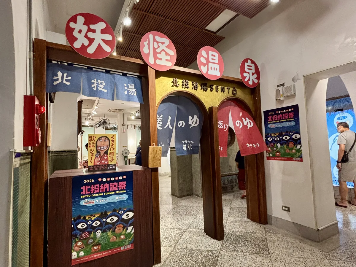 溫泉博物館內妖怪溫泉特展入口，紅白色燈籠拼成的拱門，牆上貼著北投納涼祭活動海報