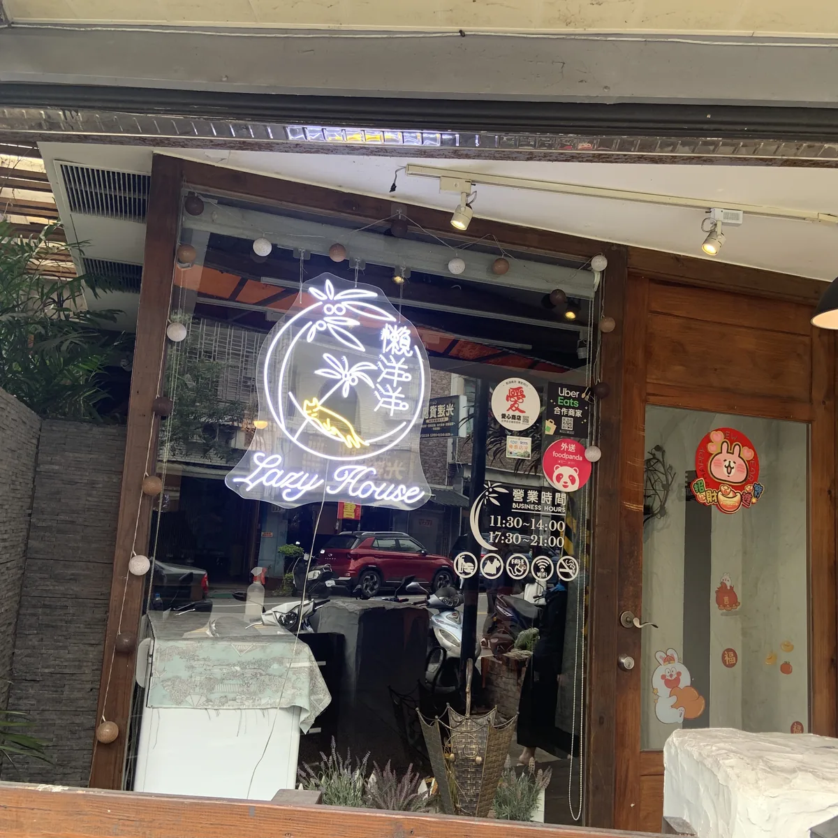 花蓮懶洋洋南洋料理Lazy House店門口霓虹招牌，寫著營業時間11:30-14:00、17:30-21:00