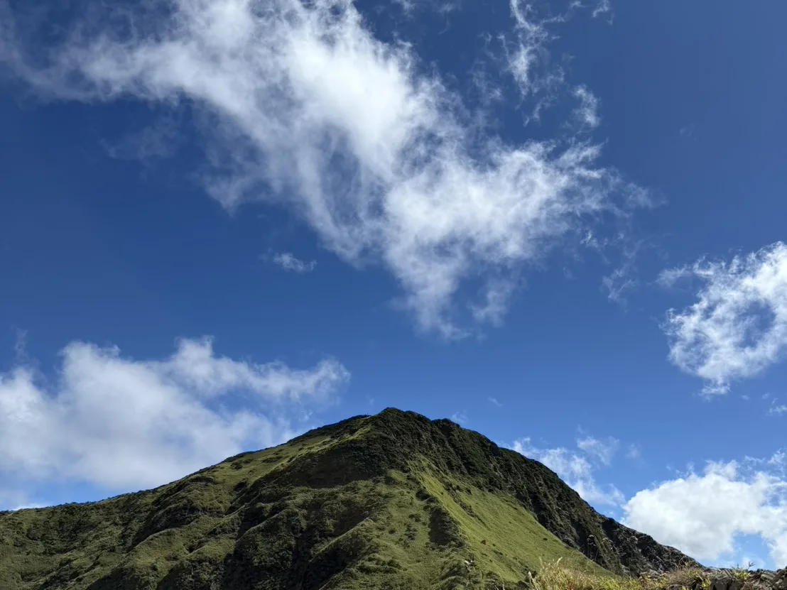 合歡山區草坡狀的山頭，藍天白雲下步道通往山頂