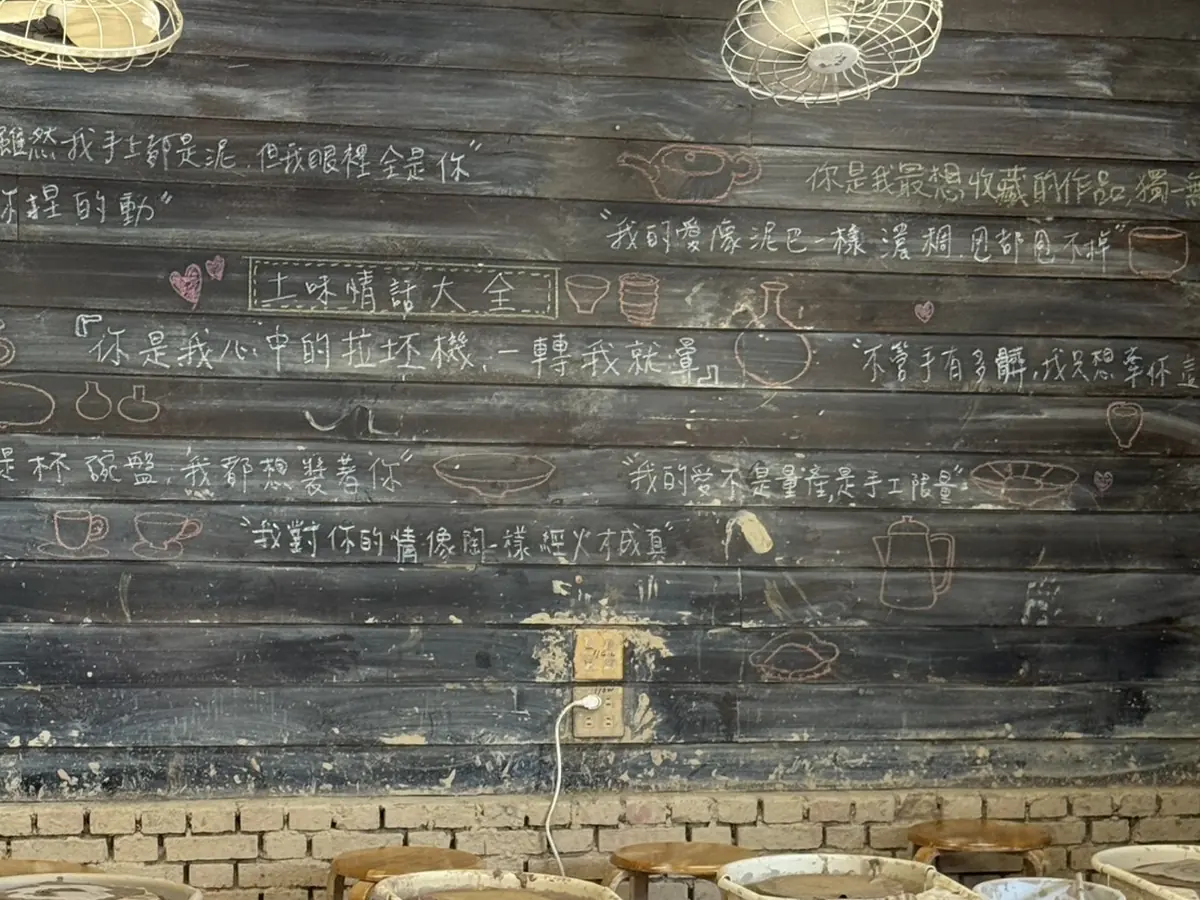 水里蛇窯玩陶教室的木板牆，用粉筆寫滿土味情話大全與陶器塗鴉