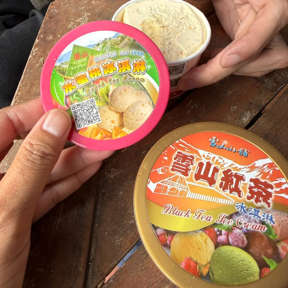 武陵農場的雪山紅茶冰淇淋，粉紅色杯蓋上印著雪山之霸與冰淇淋圖案