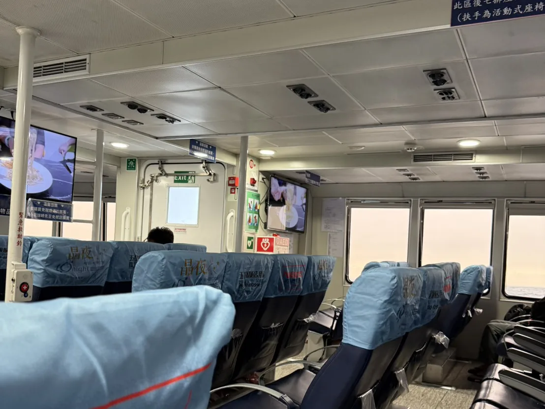 東琉線客船船艙內部，藍色座椅與窗外的海面景色