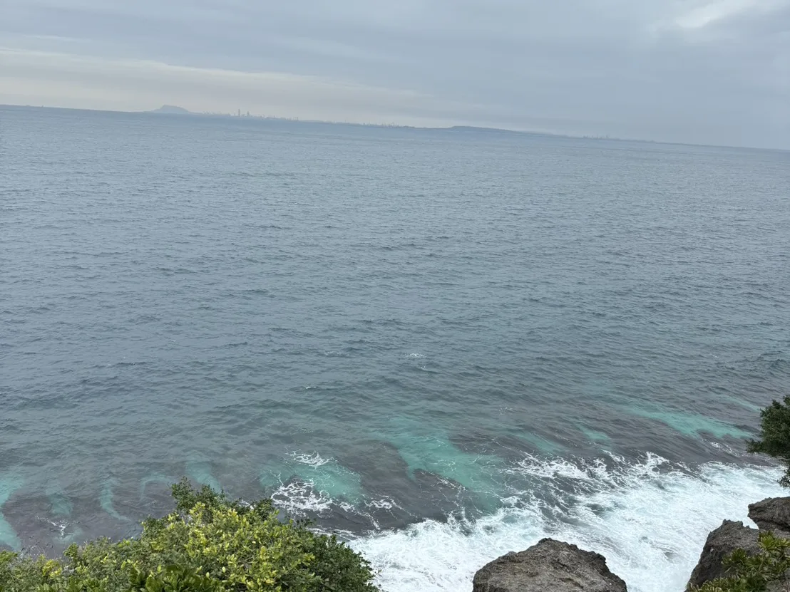小琉球海崖眺望遠方高雄市區輪廓，海面呈現層次分明的藍綠色