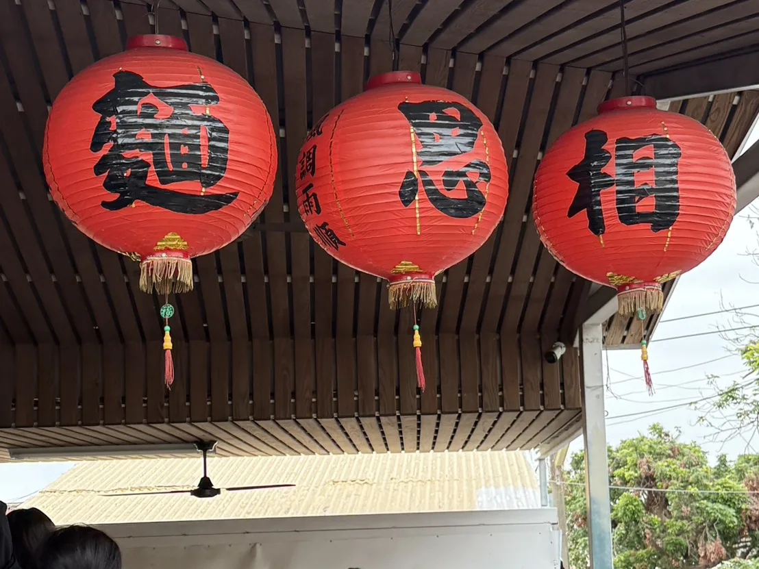 小琉球相思麵店外掛著紅燈籠的用餐區，遊客坐在戶外棚下吃麵