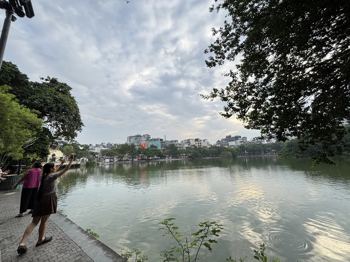 清晨的河內還劍湖，湖邊步道上有人散步