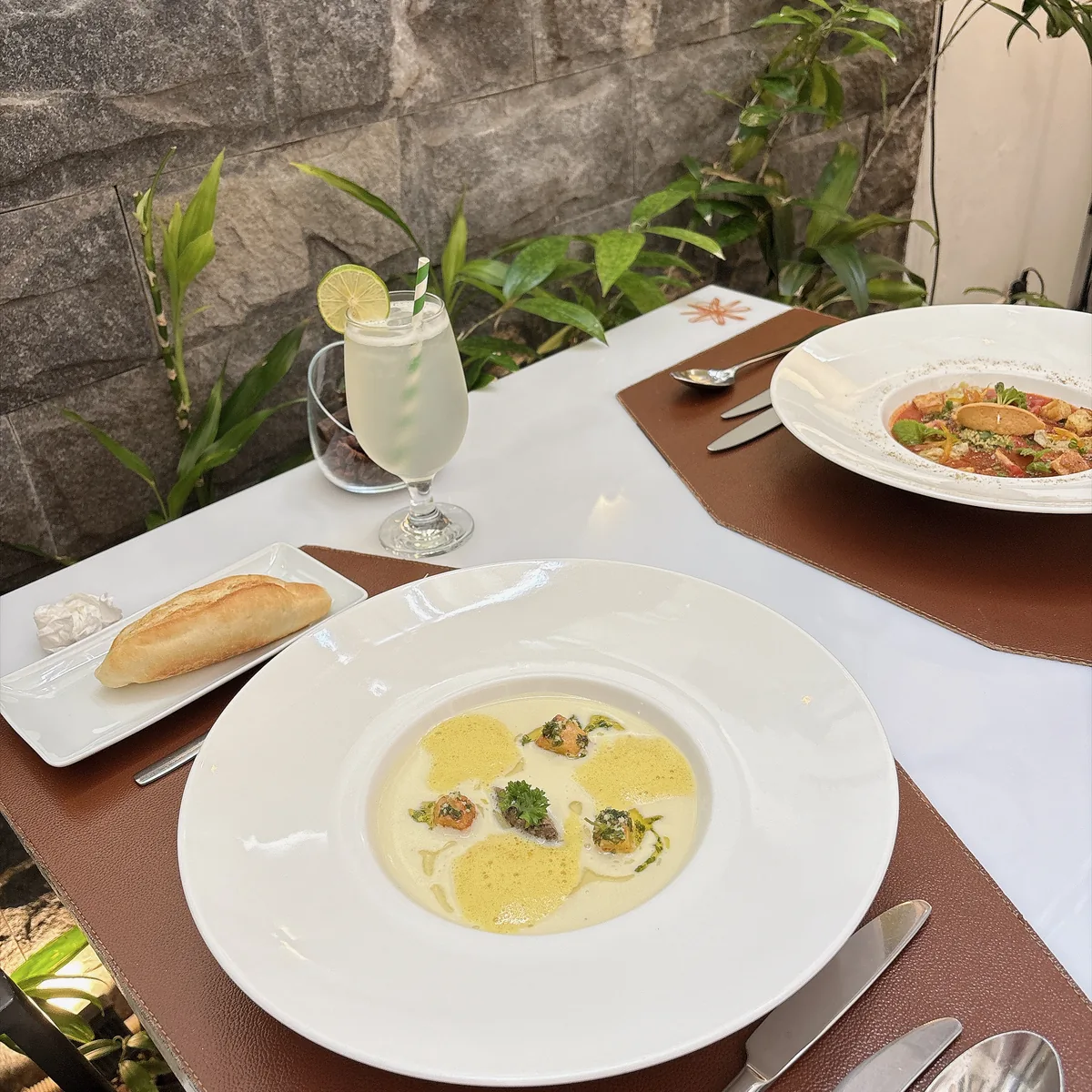 la badiane 餐廳的前菜濃湯與麵包，戶外座位擺著白桌巾