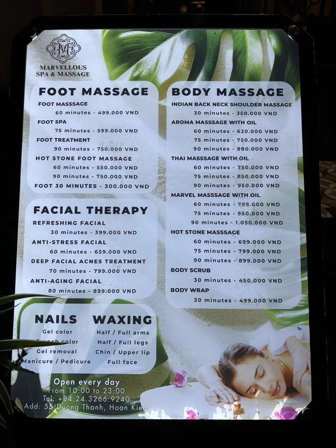 河內 SPA 店的燈箱價目表，分成腳底按摩、全身按摩、臉部療程與美甲四大類