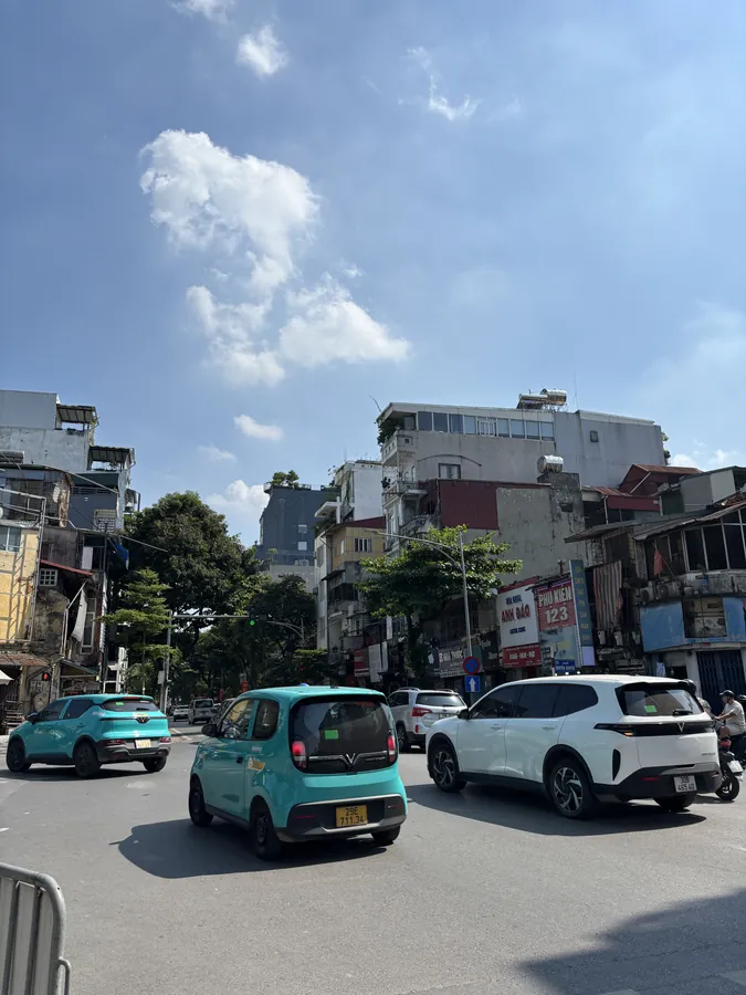 河內市區馬路上的汽車與機車車流，兩旁是老舊樓房