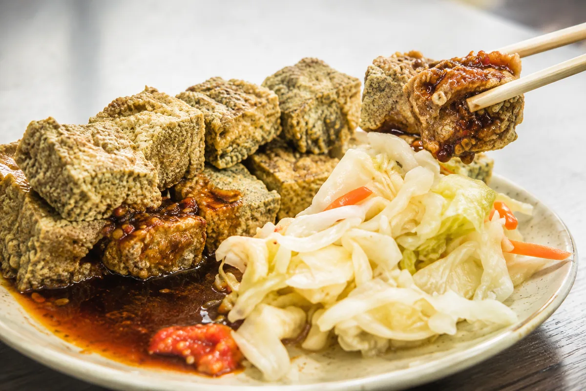 酥炸臭豆腐佐蒜蓉甜辣醬與酸白菜，外皮帶點深綠焦香色澤，是礁溪街上常見的平價小吃（示意圖，非現場實拍）