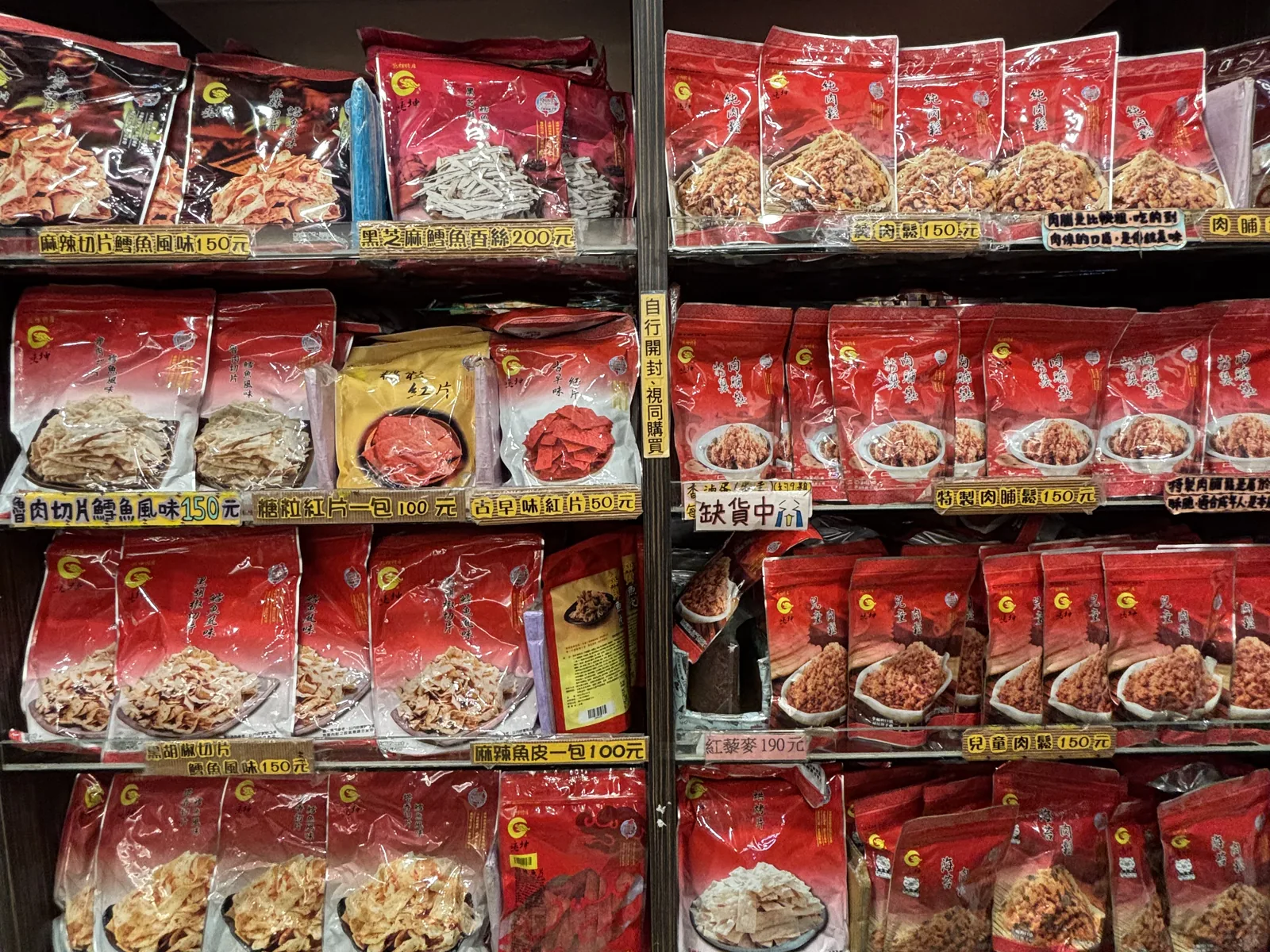 苗栗苑裡垂坤名產店貨架，整面牆掛滿肉鬆、肉脯、鱈魚香絲與紅片等古早味零食
